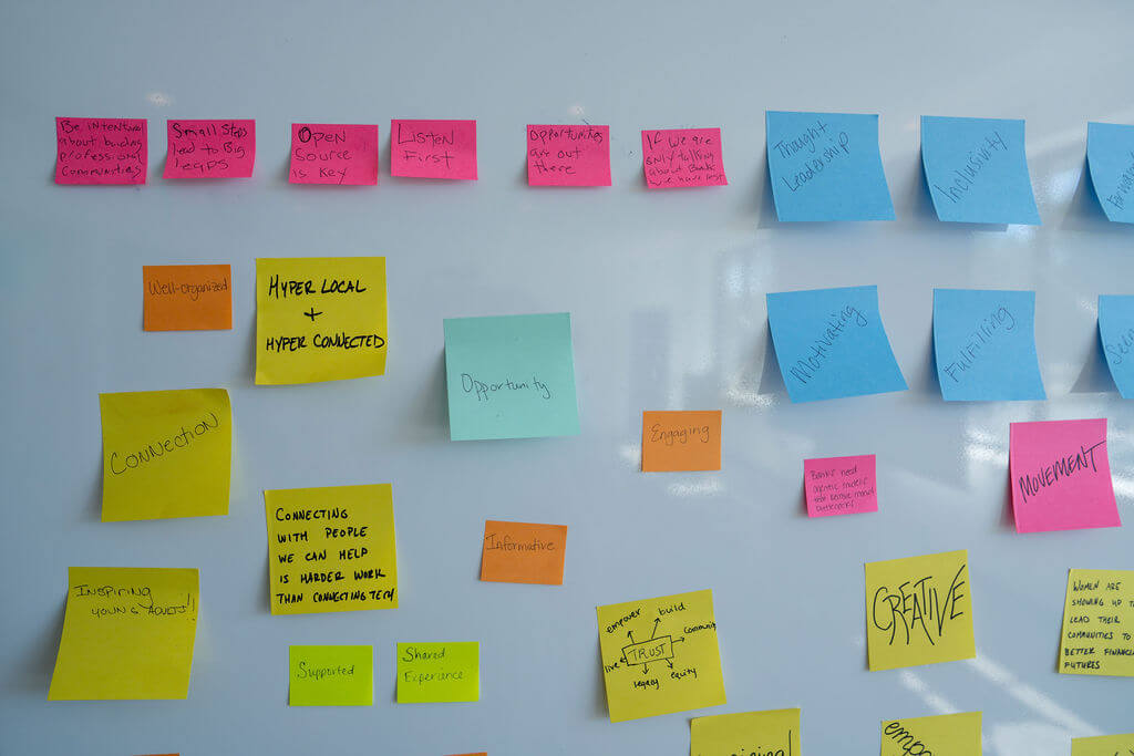 Colorful sticky notes arranged on a whiteboard during a collaborative workshop activity.