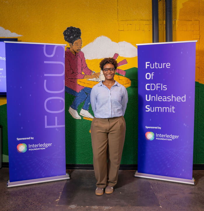 Casey Diké standing in front of the mural and FOCUS banners.